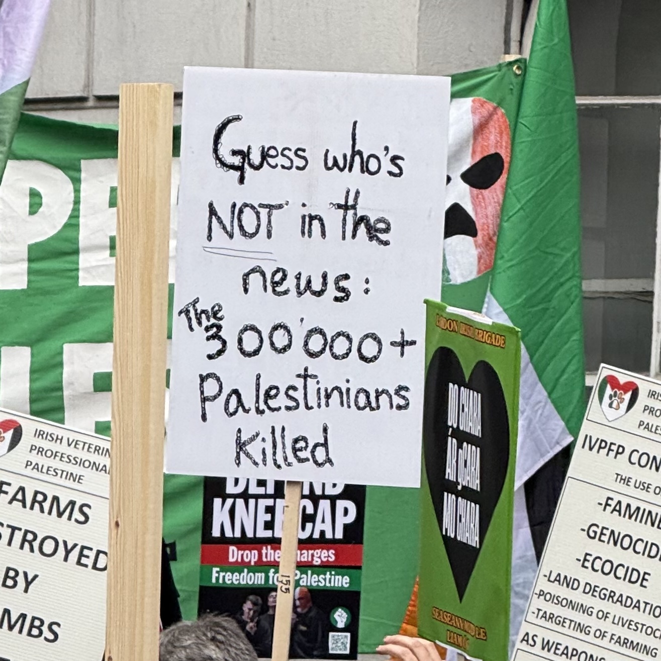 A placard that reads: Guess who's not on the news the 300,000+ Palestinians killed. Which is a pun on a kneecap lyric Guess who's back on the news from Get yer Brits out.