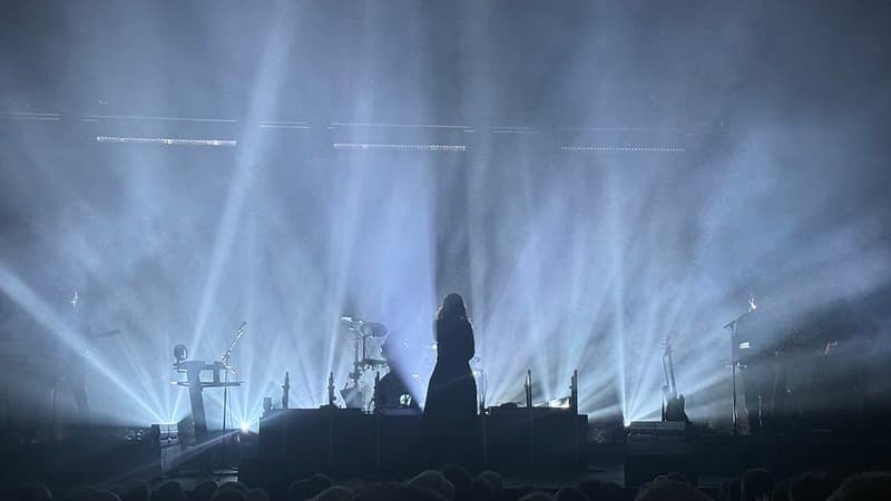 A silhouette of Alison Moyet with white lights in the background
