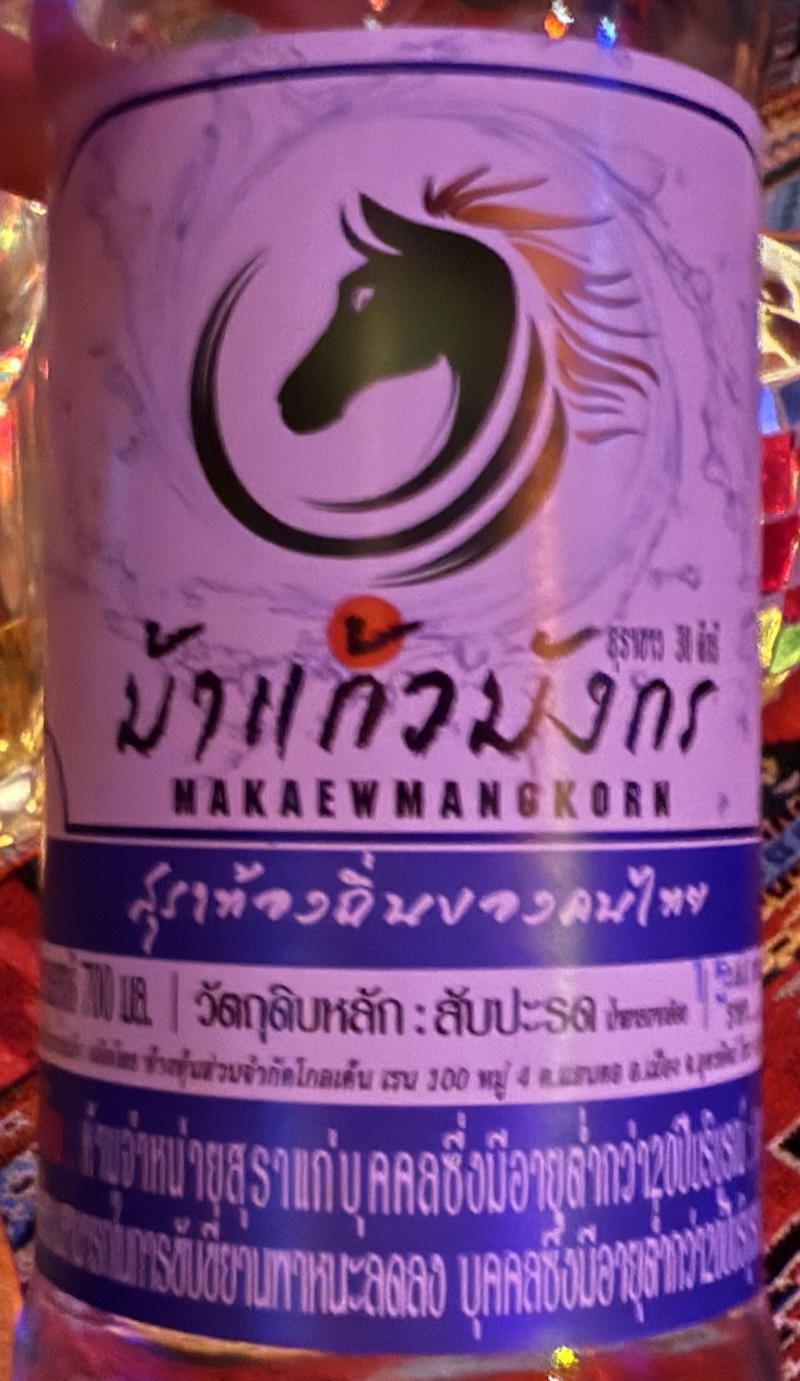 Bottle of spirit with a horse's head and a some writing in Thai script