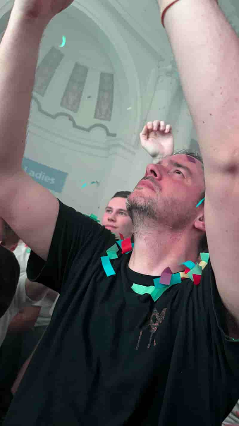 My friend Bramus dancing to Born Slippy NUXX, his arms are raised in the air as though he is worshipping Underworld (he probably was) and he is covered in confetti